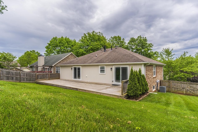 back of property with cooling unit, a deck, a shingled roof, and brick siding