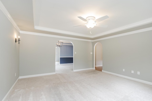 unfurnished room with arched walkways, a raised ceiling, a ceiling fan, light colored carpet, and crown molding