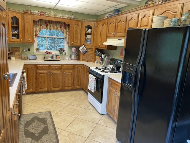 218 W Campbell St, Frankfort, KY 40601 - kitchen featuring black refrigerator with ice dispenser, white gas range oven, under cabinet range hood, brown cabinetry, and light countertops