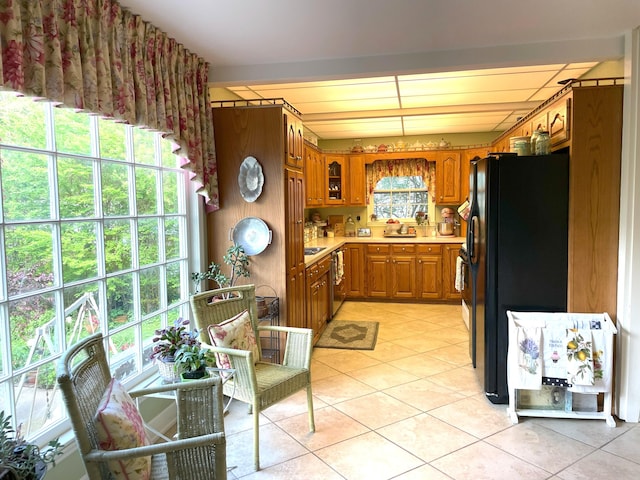 218 W Campbell St, Frankfort, KY 40601 - kitchen with freestanding refrigerator, brown cabinetry, light tile patterned flooring, light countertops, and glass insert cabinets