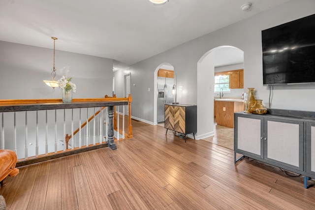 501 Ashley Ct, Berea, KY 40403 - corridor featuring an upstairs landing, arched walkways, light wood-style floors, a sink, and baseboards