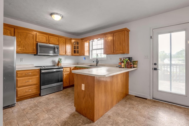 501 Ashley Ct, Berea, KY 40403 - kitchen featuring stainless steel appliances, a sink, a peninsula, and light countertops