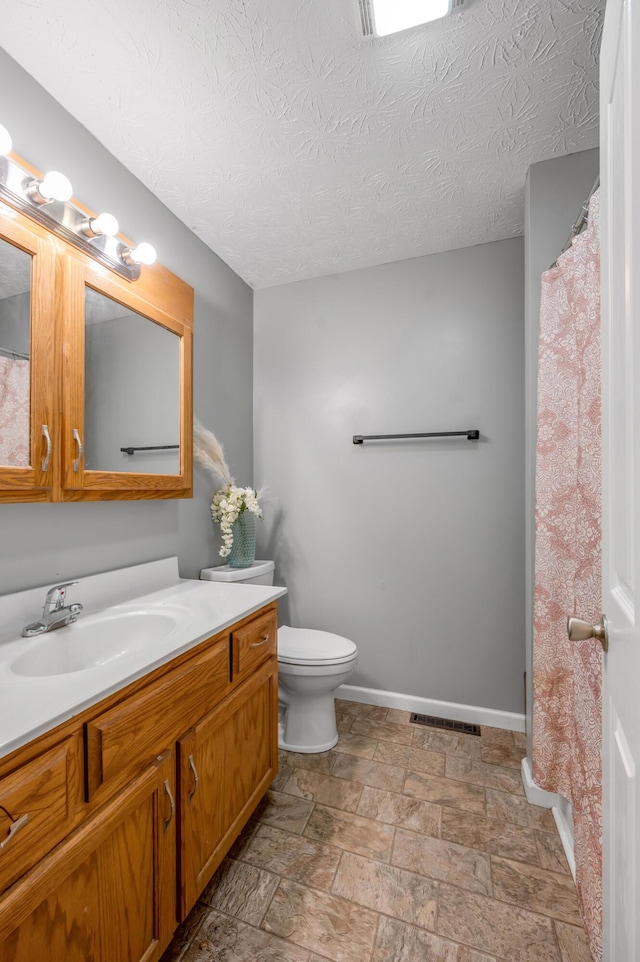 501 Ashley Ct, Berea, KY 40403 - full bath with baseboards, vanity, toilet, stone finish floors, and a textured ceiling