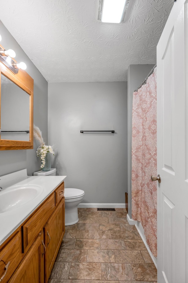 501 Ashley Ct, Berea, KY 40403 - full bathroom with vanity, baseboards, toilet, stone finish flooring, and a textured ceiling