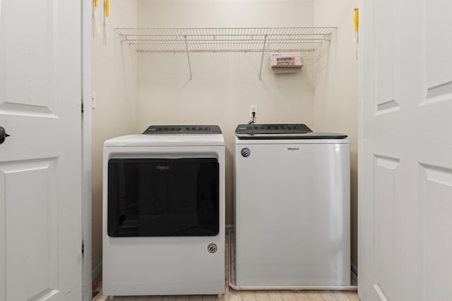 laundry room featuring washing machine and dryer and light wood-style floors