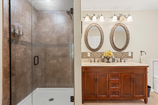 full bath with a stall shower, tasteful backsplash, double vanity, and a textured ceiling