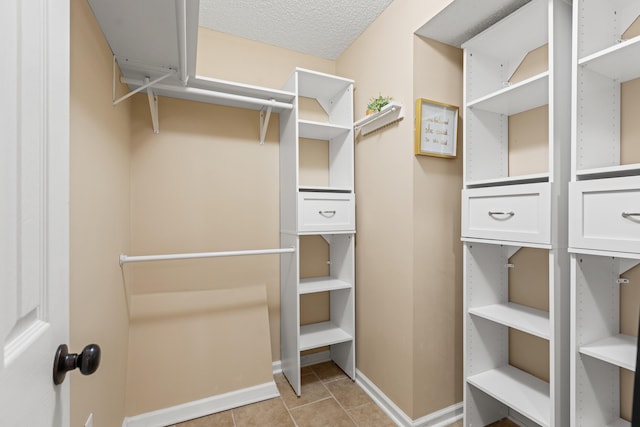 walk in closet with light tile patterned flooring