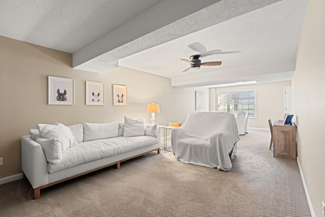 carpeted living room featuring a textured ceiling, a ceiling fan, and baseboards