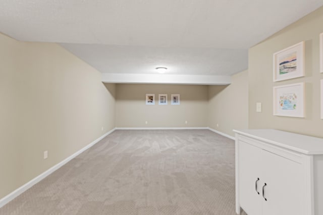 finished basement with light colored carpet and baseboards