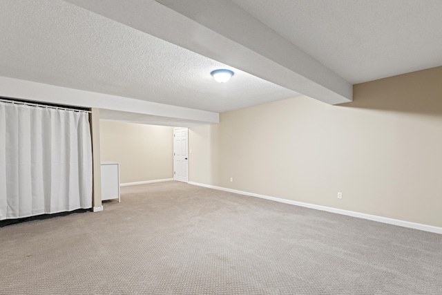 finished basement featuring carpet, baseboards, and a textured ceiling