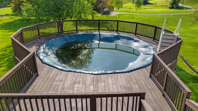 view of swimming pool with a wooden deck and a yard