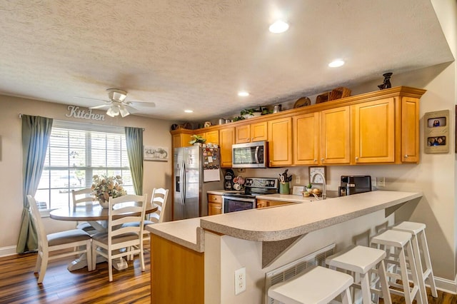 129 General Cleburne Dr, Richmond, KY 40475 - kitchen with appliances with stainless steel finishes, dark wood finished floors, light countertops, a peninsula, and baseboards