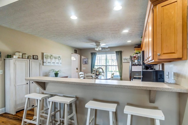 129 General Cleburne Dr, Richmond, KY 40475 - kitchen with freestanding refrigerator, a peninsula, light countertops, a ceiling fan, and a textured ceiling