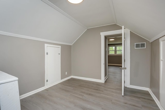 bonus room featuring wood finished floors, lofted ceiling, and baseboards