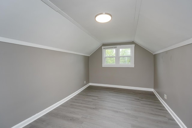 bonus room featuring wood finished floors, lofted ceiling, and baseboards