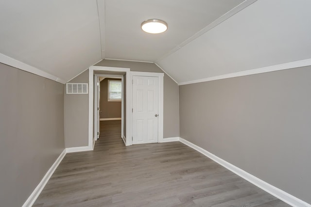 additional living space with lofted ceiling, baseboards, and wood finished floors