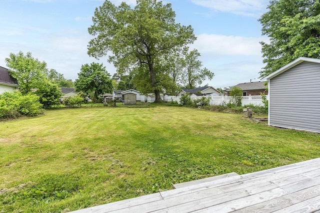 view of yard with fence, a wooden deck, and a residential view