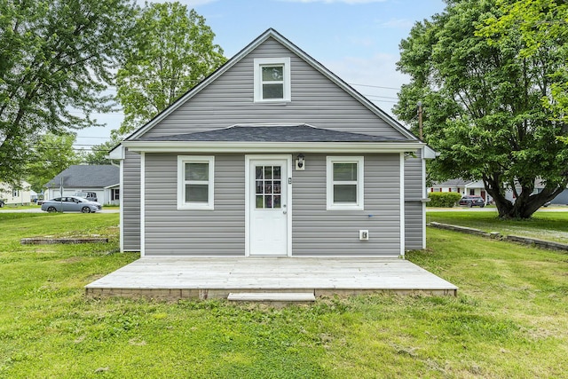 back of property featuring a lawn and a deck