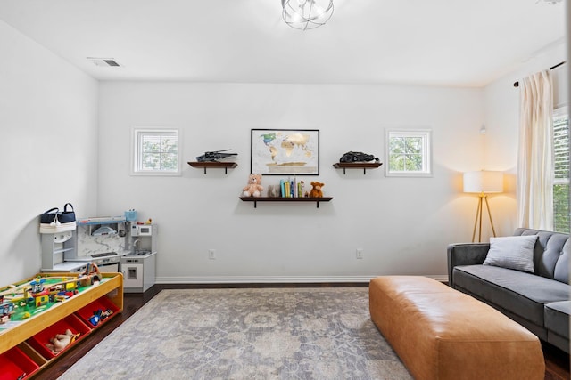 living area with wood finished floors, healthy amount of natural light, and baseboards