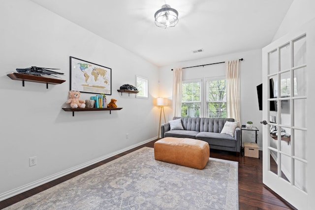 living area with dark wood-style flooring and baseboards