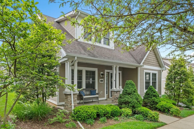 view of front of house featuring covered porch and a shingled roof