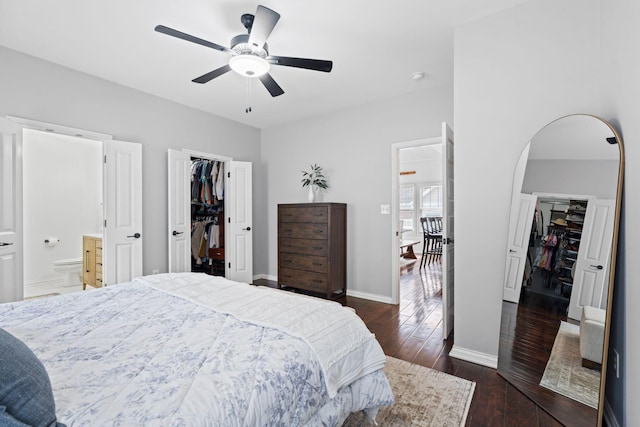 bedroom with a walk in closet, a closet, dark wood-type flooring, and ensuite bath