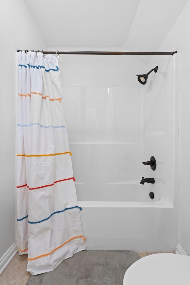 bathroom featuring shower / bath combo, baseboards, and toilet