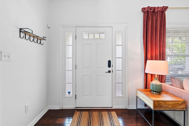 foyer featuring dark wood-type flooring and baseboards