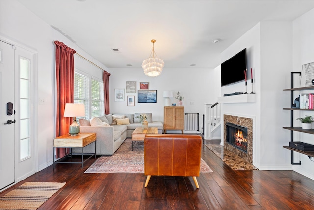 living room featuring hardwood / wood-style flooring, a chandelier, and a fireplace