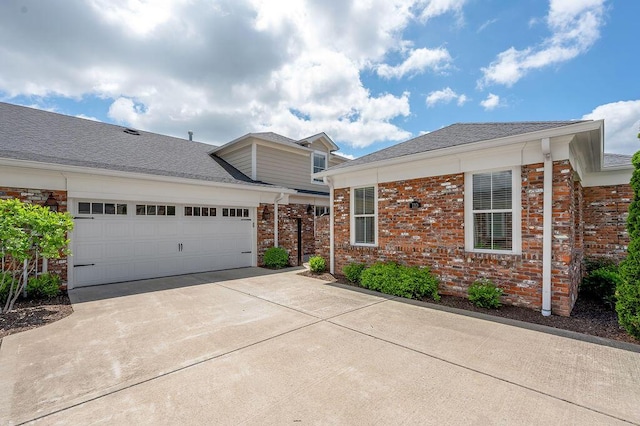 view of front of house with concrete driveway, a garage, and brick siding