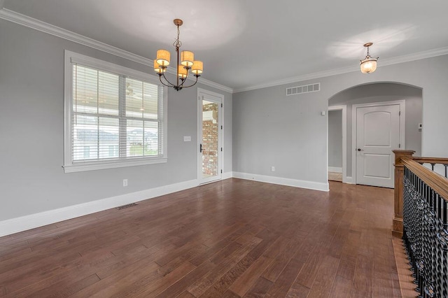 unfurnished room featuring a chandelier, arched walkways, dark wood-type flooring, ornamental molding, and baseboards