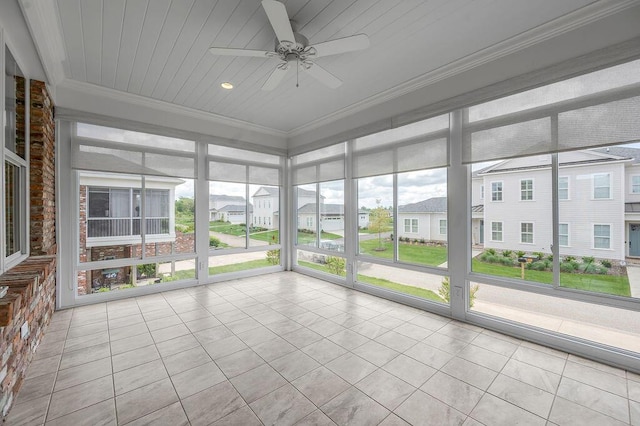 unfurnished sunroom featuring a ceiling fan and a residential view