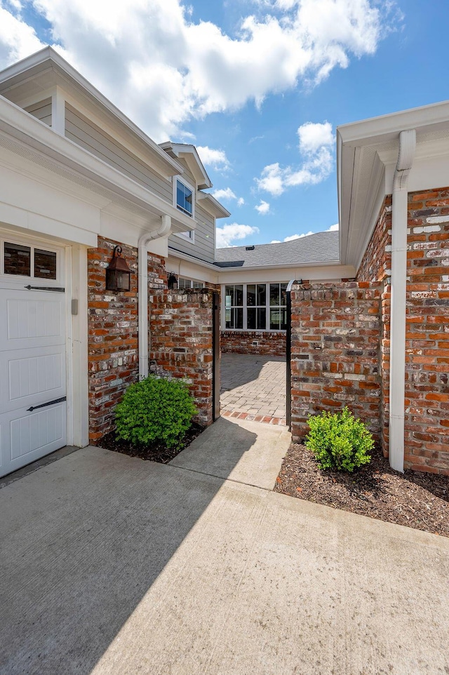 entrance to property featuring brick siding and a garage