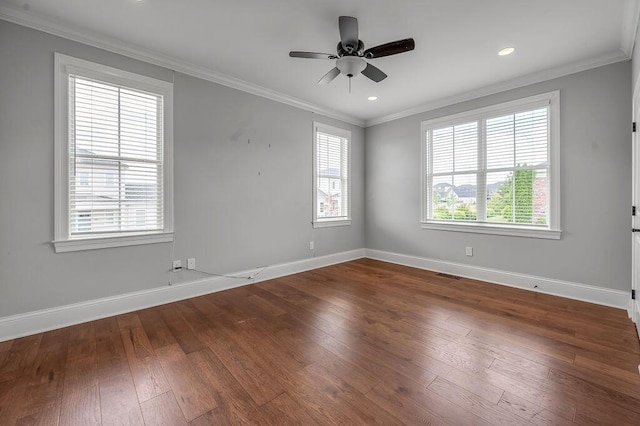 unfurnished room with healthy amount of natural light, crown molding, baseboards, dark wood-type flooring, and a ceiling fan