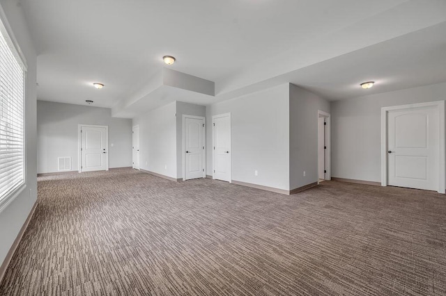 unfurnished living room featuring carpet and baseboards