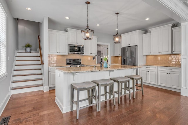 kitchen featuring appliances with stainless steel finishes, a sink, dark wood-style flooring, decorative backsplash, and recessed lighting