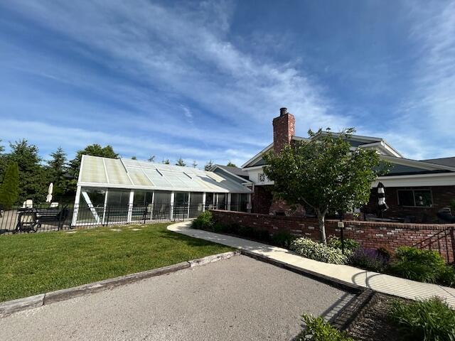 rear view of property featuring a chimney and an exterior structure