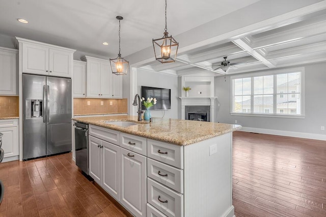 kitchen featuring stainless steel refrigerator with ice dispenser, a sink, a ceiling fan, decorative backsplash, and recessed lighting