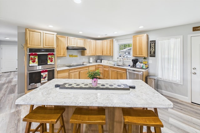 663 John R Jones Rd, London, KY 40741 - kitchen featuring light brown cabinetry, appliances with stainless steel finishes, under cabinet range hood, a sink, and a kitchen bar