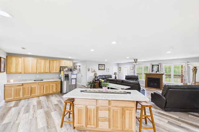 663 John R Jones Rd, London, KY 40741 - kitchen featuring stainless steel refrigerator with ice dispenser, a breakfast bar area, light wood-style floors, recessed lighting, and a fireplace
