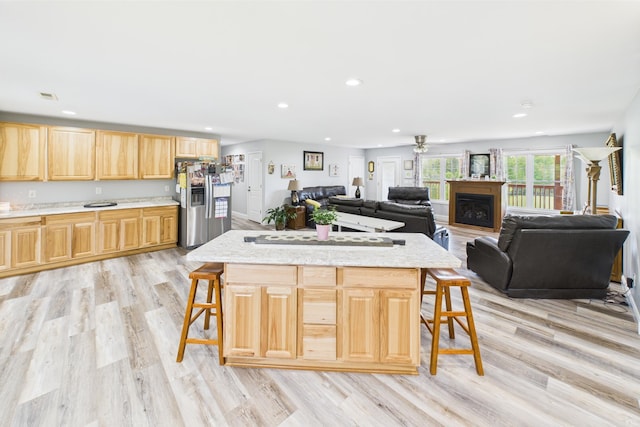 663 John R Jones Rd, London, KY 40741 - kitchen featuring light brown cabinetry, stainless steel fridge, a kitchen bar, light wood-type flooring, and recessed lighting