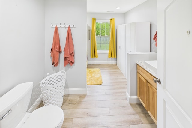 663 John R Jones Rd, London, KY 40741 - bathroom featuring wood finished floors, toilet, baseboards, vanity, and recessed lighting