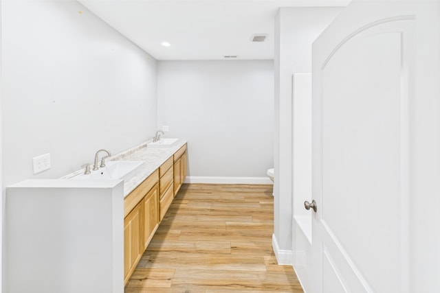 663 John R Jones Rd, London, KY 40741 - full bathroom with wood finished floors, toilet, double vanity, baseboards, and recessed lighting