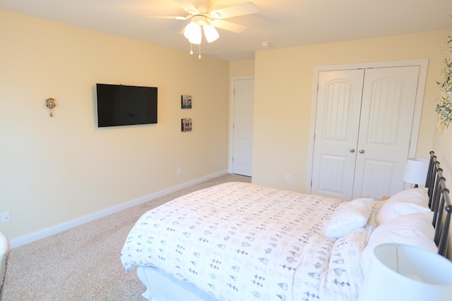 carpeted bedroom featuring a closet, baseboards, and ceiling fan