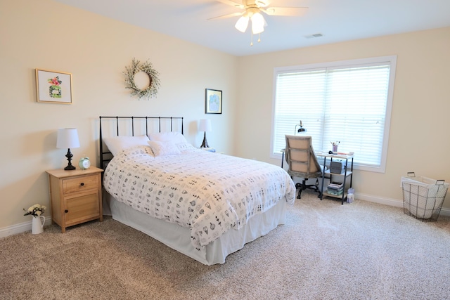 bedroom with light colored carpet, baseboards, and a ceiling fan