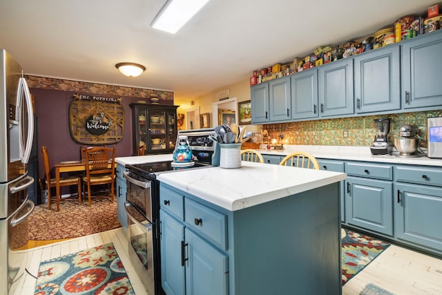 429 Old Danville Rd, Lancaster, KY 40444 - kitchen featuring appliances with stainless steel finishes, blue cabinetry, a center island, and decorative backsplash
