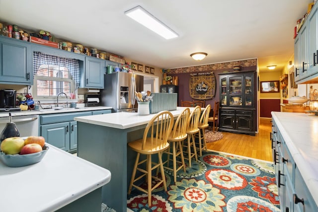 429 Old Danville Rd, Lancaster, KY 40444 - kitchen with appliances with stainless steel finishes, a sink, light countertops, a kitchen island, and a kitchen breakfast bar