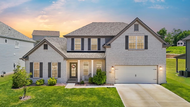 view of front of house with brick siding, a shingled roof, and a front yard