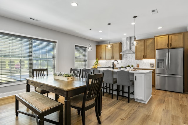 dining room with plenty of natural light, light wood-type flooring, recessed lighting, and baseboards