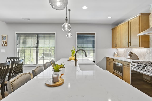 kitchen featuring stainless steel appliances, backsplash, decorative light fixtures, a sink, and recessed lighting